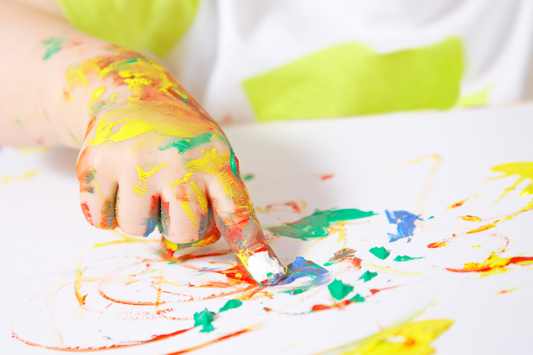 Baby's hand covered in paint while finger painting